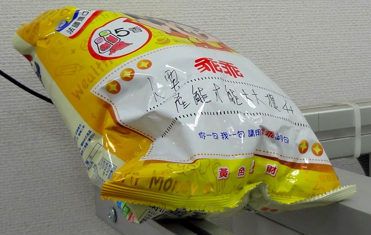 黃色五香乖乖造句包放在輸送帶上的真實照片